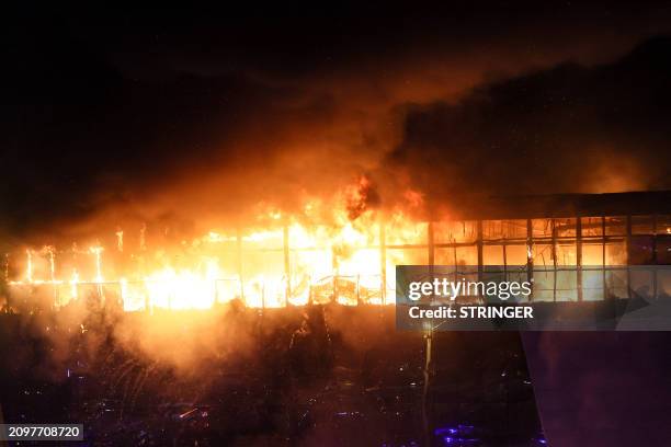 View shows the burning Crocus City Hall concert hall following the shooting incident in Krasnogorsk, outside Moscow, on March 22, 2024. Gunmen opened...