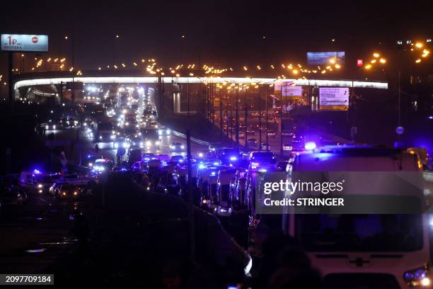 Ambulances are seen at the scene of the shooting at the Crocus City Hall concert hall in Krasnogorsk, outside Moscow, on March 22, 2024. Gunmen...