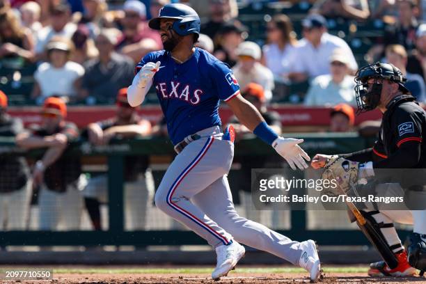 Ezequiel Duran of the Texas Rangers hits a single in the second inning during a spring training game against the San Francisco Giants at Scottsdale...