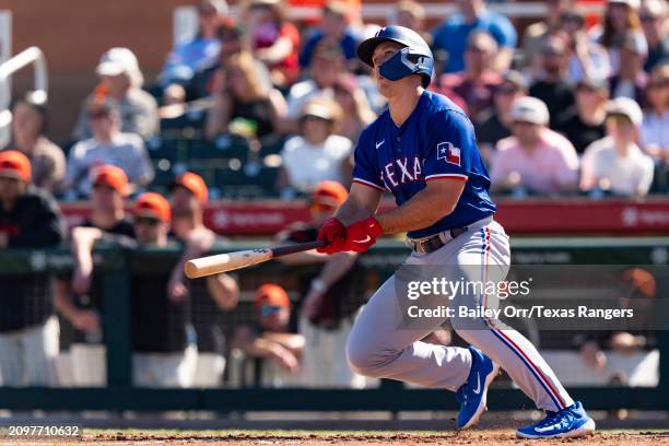 Wyatt Langford of the Texas Rangers hits a single in the third inning during a spring training game against the San Francisco Giants at Scottsdale...