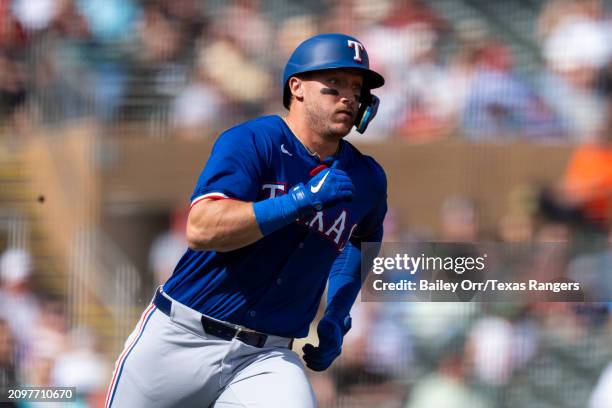 Andrew Knizner of the Texas Rangers rounds the bases after hitting a three-run home run in the second inning during a spring training game against...