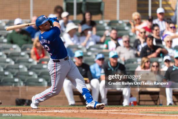 Andrew Knizner of the Texas Rangers hits a three-run home run in the second inning during a spring training game against the Arizona Diamondbacks at...