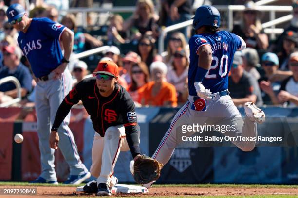 Ezequiel Duran of the Texas Rangers beats out the throw to first after hitting a single in the second inning during a spring training game against...