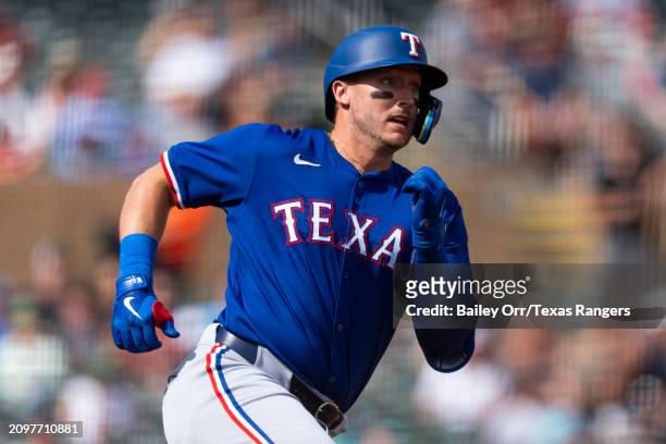 Andrew Knizner of the Texas Rangers rounds the bases after hitting a three-run home run in the second inning during a spring training game against...