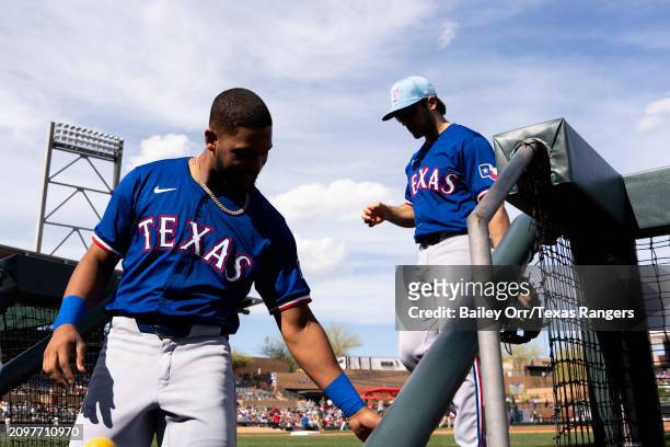 Leody Taveras and Josh Smith of the Texas Rangers look on in the dugout during a spring training game against the Arizona Diamondbacks at Salt River...