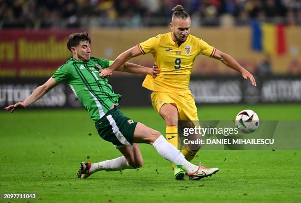 Romania's forward George Puscas and Northern Ireland's midfielder Paddy McNair vie for the ball during the friendly football match between Romania...