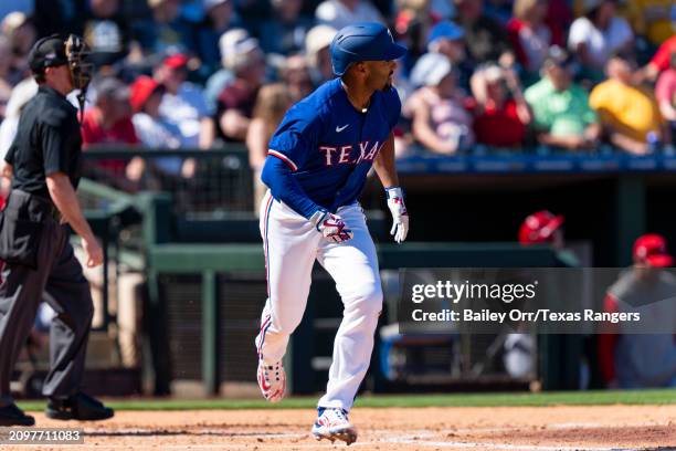Marcus Semien of the Texas Rangers hits a solo home run in the third inning during a spring training game against the Los Angeles Angels at Surprise...