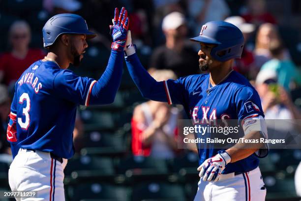 Marcus Semien celebrates with Leody Taveras of the Texas Rangers after hitting a solo home run in the third inning during a spring training game...