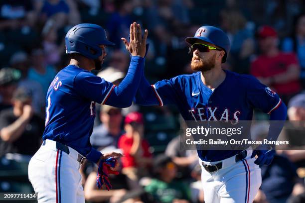 Jared Walsh celebrates with Leody Taveras of the Texas Rangers after hitting a two-run home run in the third inning during a spring training game...