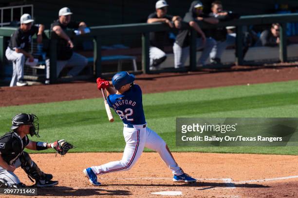 Wyatt Langford of the Texas Rangers hits a three-run home run in the sixth inning during a spring training game against the Chicago White Sox at...