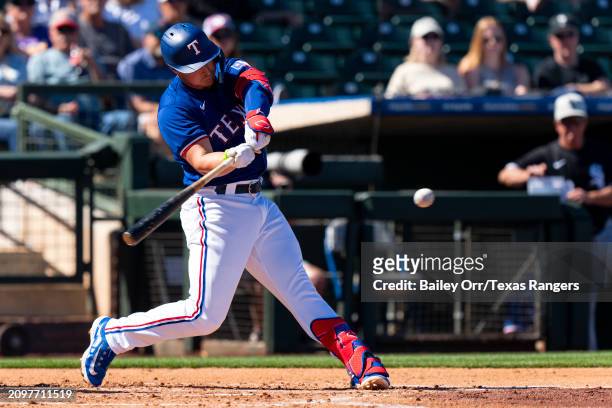 Justin Foscue of the Texas Rangers bats during a spring training game against the Chicago White Sox at Surprise Stadium on March 02, 2024 in...