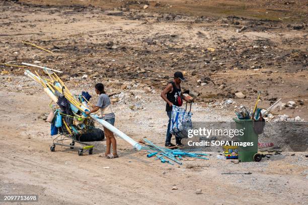 Waste pickers are seen collecting plastic pipes, on cleared land after the demolition of homes and businesses, on Lat Phrao Road, in Bangkok....