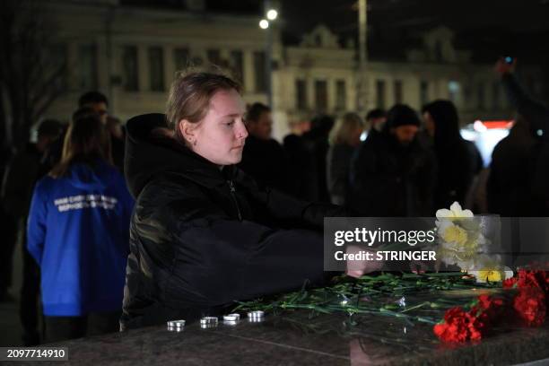 People lay flowers and lit candles in memory of the Moscow concert gun attack victims in the center of Simferopol, Crimea, on March 22, 2024. Gunmen...