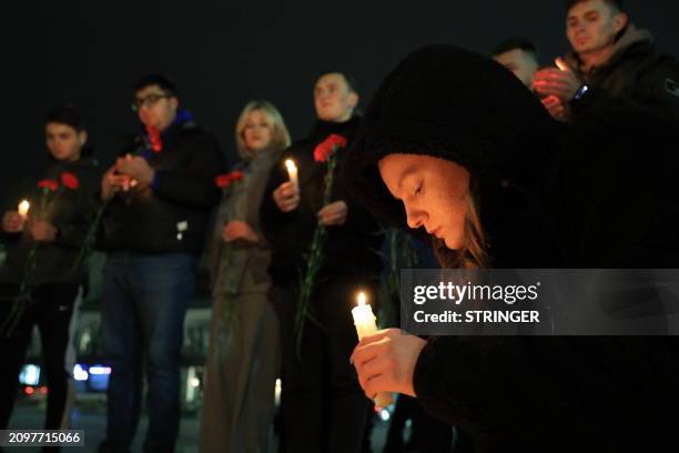 People lay flowers and lit candles in memory of the Moscow concert gun attack victims in the center of Simferopol, Crimea, on March 22, 2024. Gunmen...
