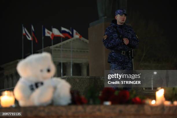 Law enforcement officer stands by a makeshift memorial for the Moscow concert gun attack victims in the center of Simferopol, Crimea, on March 22,...