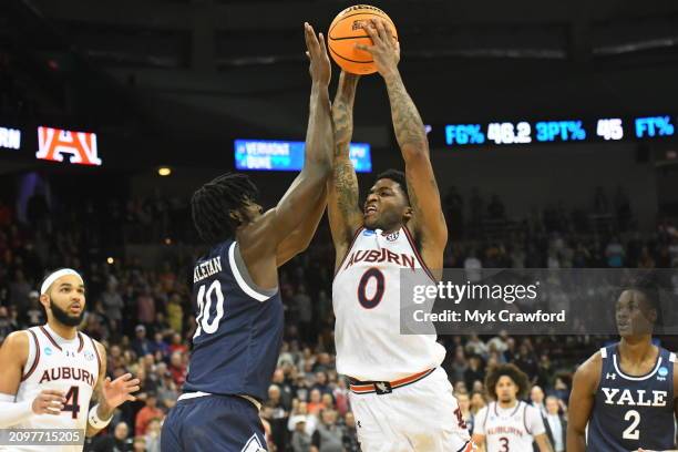 Johnson of the Auburn Tigers and Samson Aletan of the Yale Bulldogs battle for a ball during the first round of the 2024 NCAA Men's Basketball...