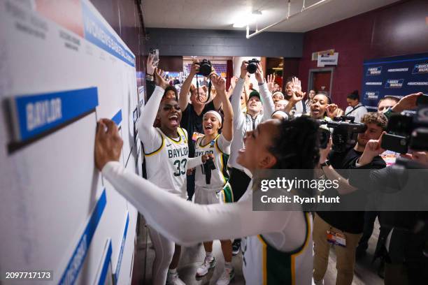 Members of the Baylor Bears moves the team's card into the second round spot on the bracket after defeating the Vanderbilt Commodores during the...