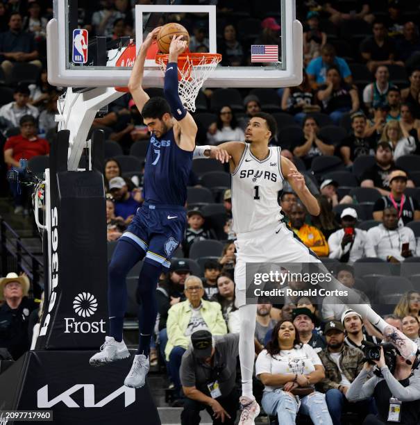 Victor Wembanyama of the San Antonio Spurs watches as Santi Aldama of the Memphis Grizzlies do a reverse dunk in the first half at Frost Bank Center...