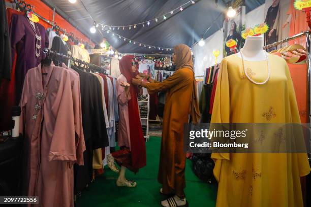 Customer tries on clothing at a Ramadan Bazaar in Kuala Lumpur, Malaysia, on Friday, March 22, 2024. Malaysia is expected to release CPI figures on...