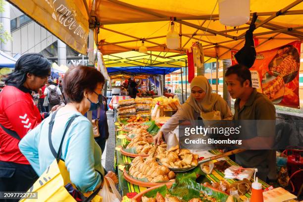 Customers buy food from a stall at a Ramadan bazaar in Kuala Lumpur, Malaysia, on Friday, March 22. 2024. Malaysia is expected to release CPI figures...