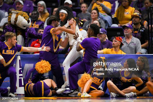 Angel Reese of the LSU Tigers falls into LSU Cheerleaders going to a ball during the first round of the 2024 NCAA Women's Basketball Tournament held...