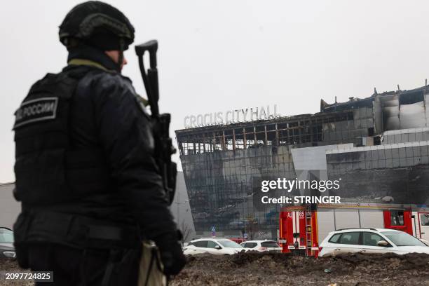 Law enforcement officer patrols the scene of the gun attack at the Crocus City Hall concert hall in Krasnogorsk, outside Moscow, on March 23, 2024....