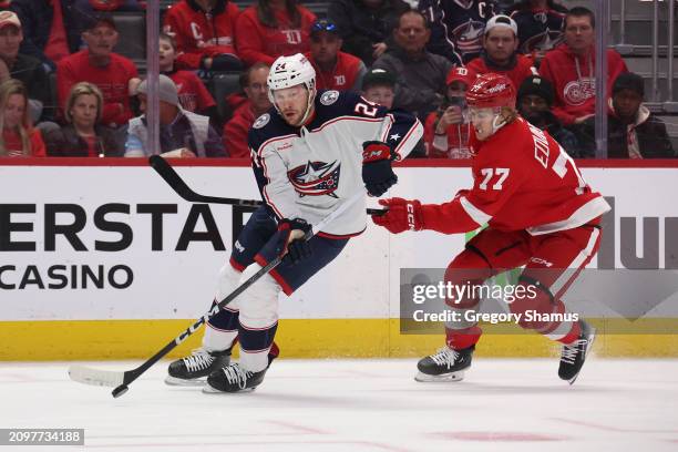 Mathieu Olivier of the Columbus Blue Jackets tries to control the puck in front of Simon Edvinsson of the Detroit Red Wings during the first period...