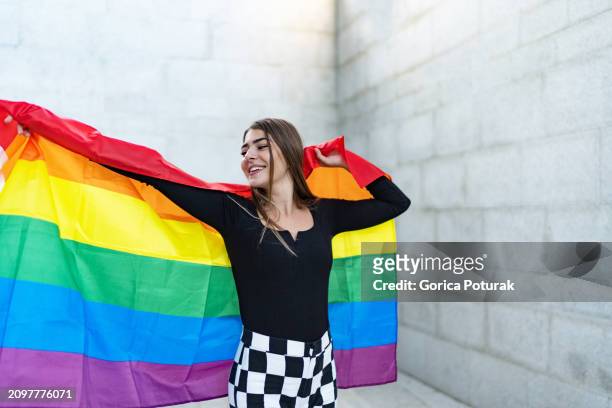 confident beautiful woman holding rainbow flag - lgbtq  female fotografías e imágenes de stock