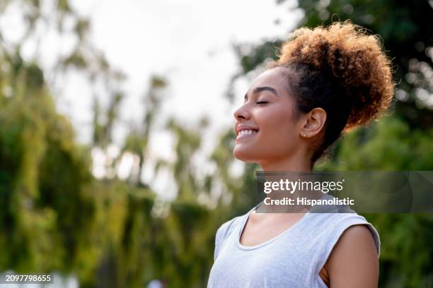 healthy woman relaxing outdoors at the park - non urban scene stock pictures, royalty-free photos & images