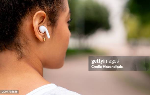 corredor al aire libre escuchando música con auriculares - hispanolistic fotografías e imágenes de stock