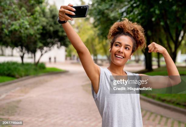 mujer fuerte tomando una selfie mientras hace ejercicio al aire libre - hispanolistic fotografías e imágenes de stock