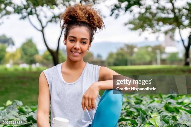 mujer de fitness haciendo ejercicio en el parque y sonriendo - hispanolistic fotografías e imágenes de stock