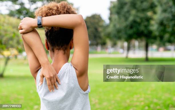 mujer en forma estirándose al aire libre en el parque - hispanolistic fotografías e imágenes de stock