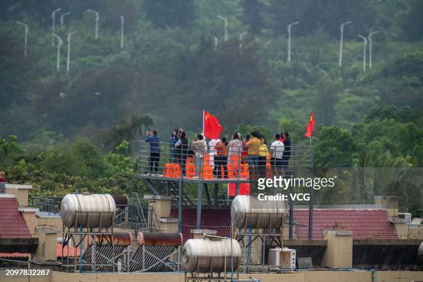 People wait on the top of a building to watch the launch of Queqiao 2 relay satellite near the Wenchang Spacecraft Launch Site on March 20, 2024 in...