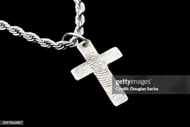 fingerprint markings on a memory necklace shaped as a cross - cristianismo imagens e fotografias de stock