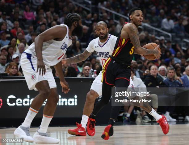 Dejounte Murray of the Atlanta Hawks drives to the basket past P.J. Tucker and James Harden of the LA Clippers during a 110-93 Hawks win at...