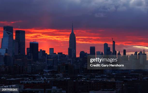 The sun rises behind the skyline of midtown Manhattan and the Empire State Building in New York City on March 19 as seen from Union City, New Jersey.