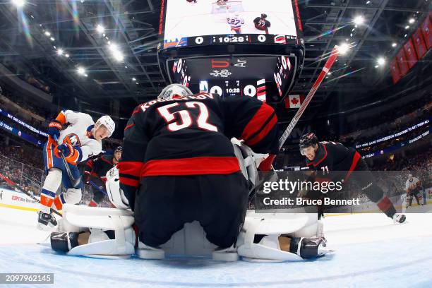 Pyotr Kochetkov of the Carolina Hurricanes defends against Simon Holmstrom of the New York Islanders during the third period at UBS Arena on March...