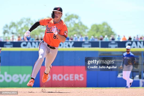 Jackson Holliday of the Baltimore Orioles rounds third base to score in the first inning against the Toronto Blue Jays during a 2024 Grapefruit...