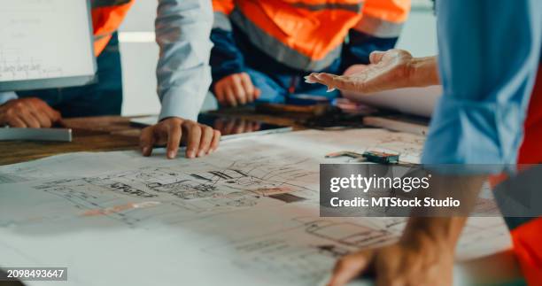 closeup of team of industrial engineers meeting analyze machinery blueprints consult project on table in manufacturing factory. working in manufacturing plant or production plant. - engineering-design-process-diagram stock pictures, royalty-free photos & images