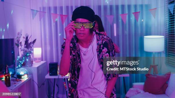 diverse group of friends dancing moving rhythmically in good mood at colorful house party at night. multicultural friends having fun together college house party. - hip hop music stock pictures, royalty-free photos & images