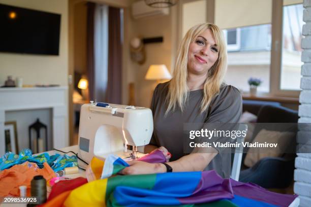using a sewing machine to mend a rainbow flag - androgynous stock pictures, royalty-free photos & images