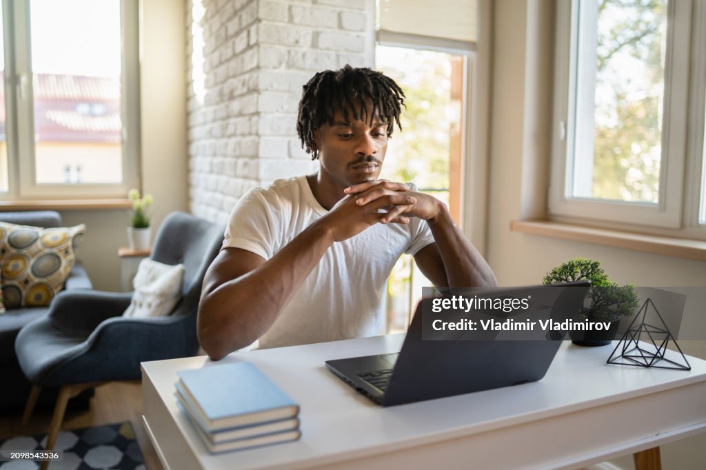 Man sat at desk looking at laptop screen