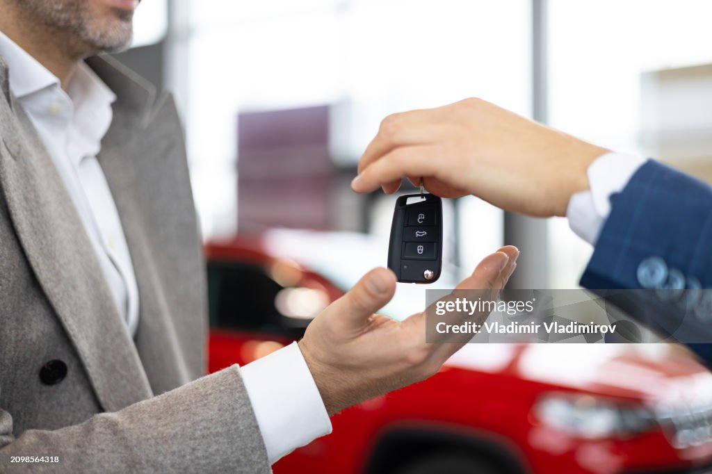 Car key handover in dealership showroom