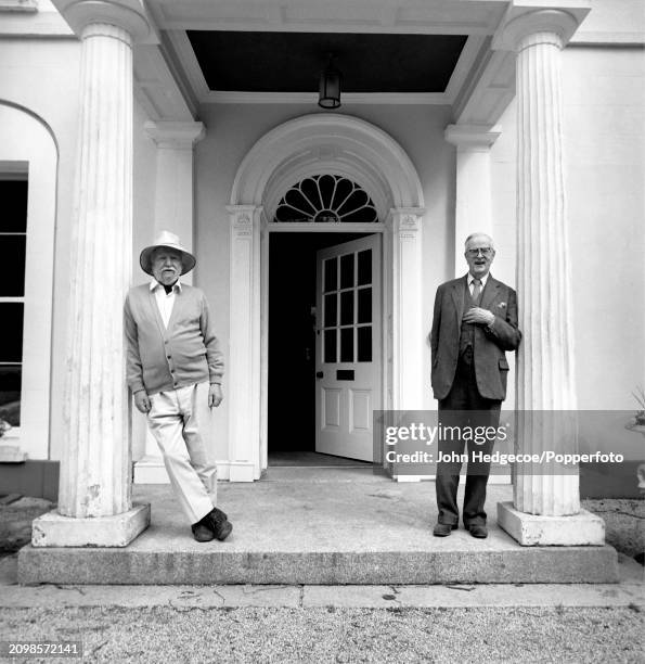 English novelist, poet and playwright William Golding stands on left with British historian A. L. Rowse outside Golding's home, Tullimaar House near...