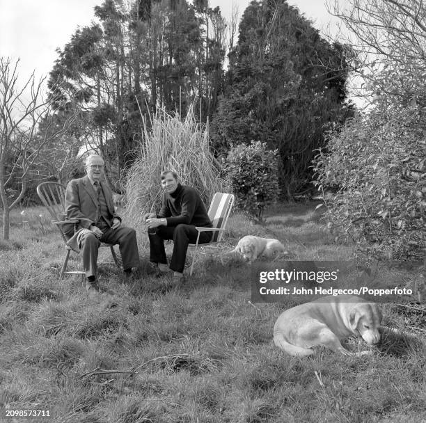 English writer and novelist Colin Wilson seated on right with British historian A. L. Rowse in the garden of Wilson's house in Cornwall, England in...