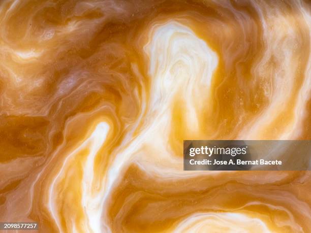 full frame of latte in motion inside the cup. - milk splat stock pictures, royalty-free photos & images