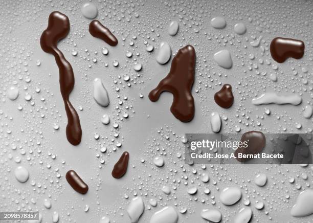 drops of hot liquid chocolate on a white surface with small drops of water. - chocolate chip stock pictures, royalty-free photos & images