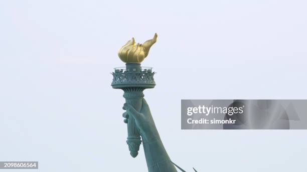 goldene fackel in der freiheitsstatue - fackel stock-fotos und bilder