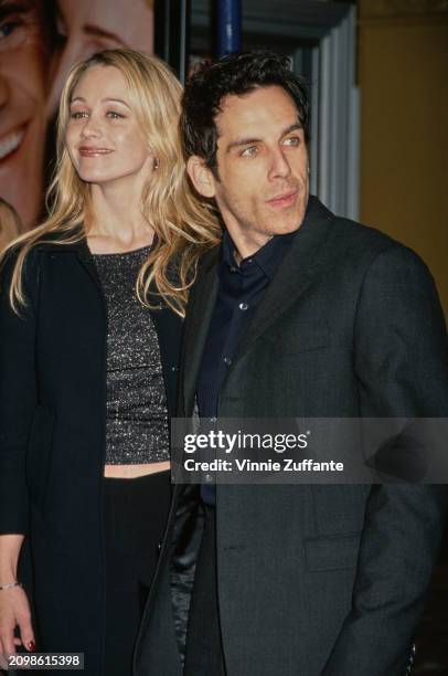 American actress Christine Taylor, wearing a black coat, and her husband, American actor and comedian Ben Stiller, who wears a black suit, attend the...